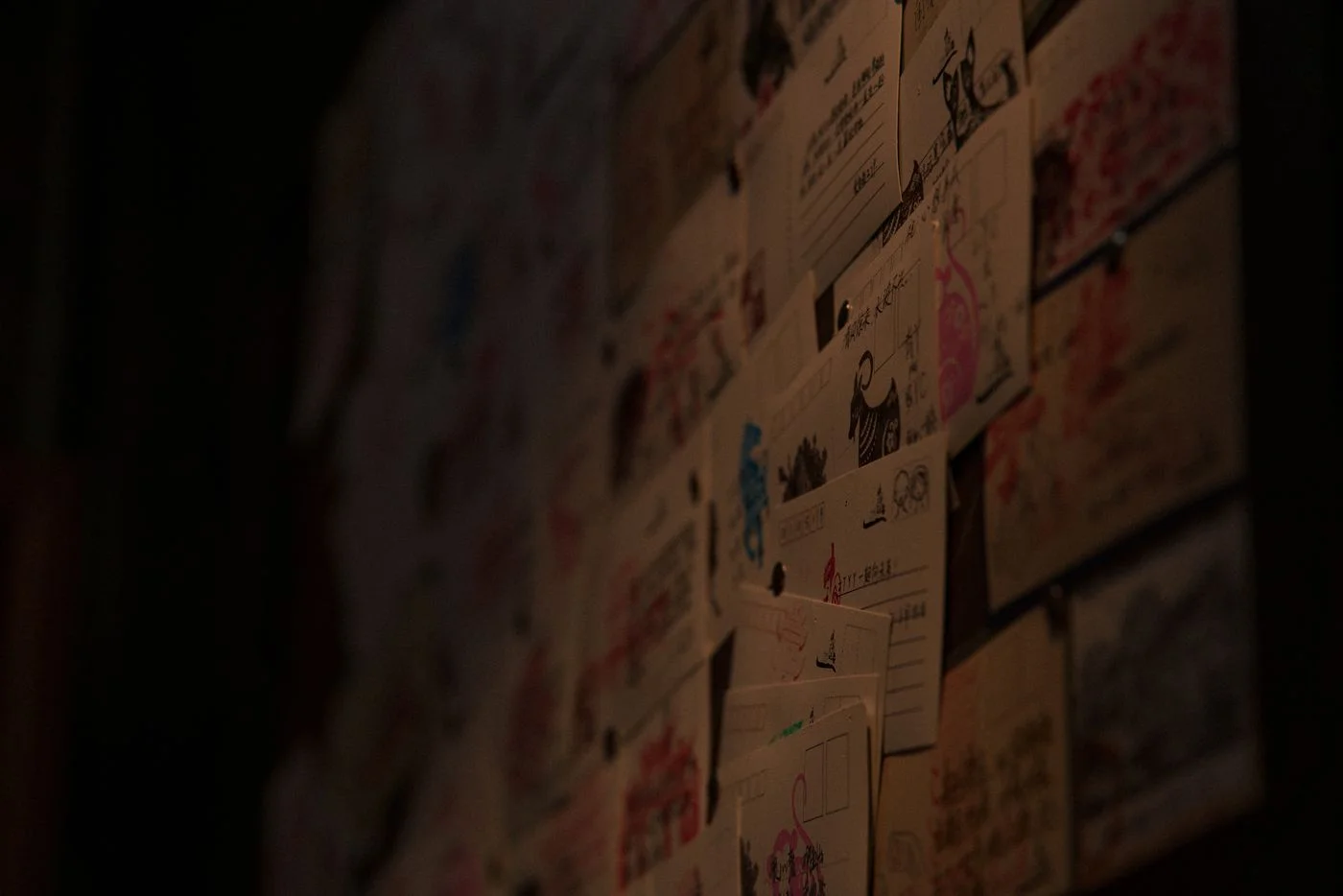 A display board holding postcards and illustrated cards.