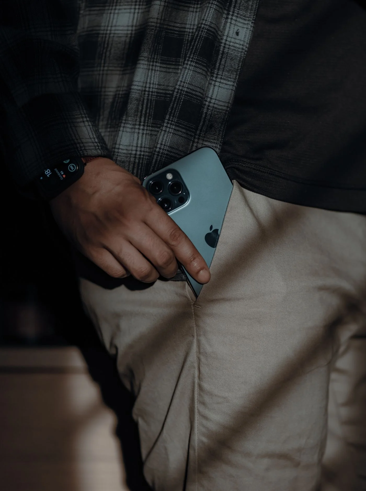 A person placing a smartphone into a trouser pocket.